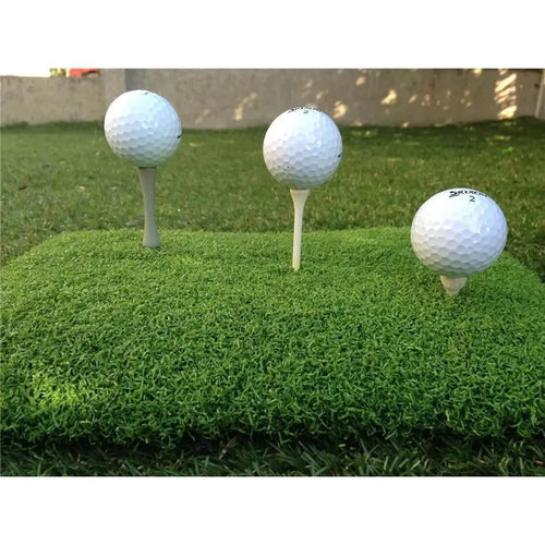 Drei Golfbälle auf Abschlagmatte mit Tees, perfektes Indoor Golf Zubehör für Training.