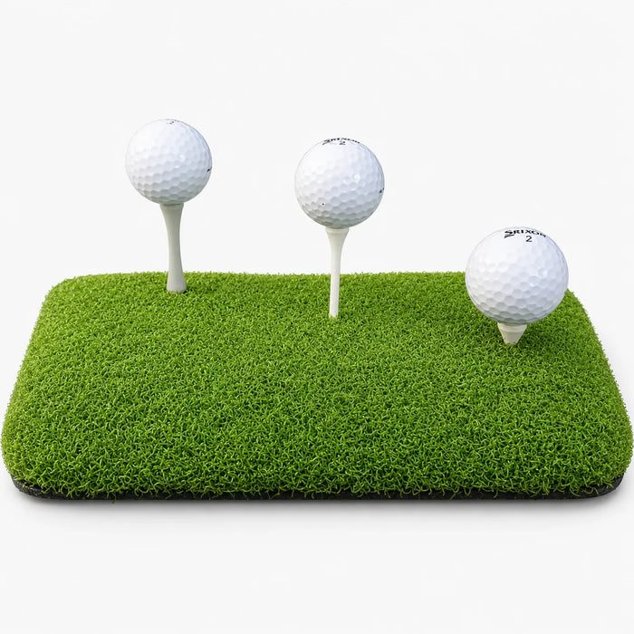 Tee Turf XL podložka na odpalovanie v interiéri s tromi golfovými loptičkami na zelenej ploche.