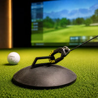 Sebo T Golf-Tee auf einem Indoor-Golfplatz mit Simulator im Hintergrund.