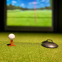 Sebo T Golfball auf Tee vor einem simulierten Golfplatz.